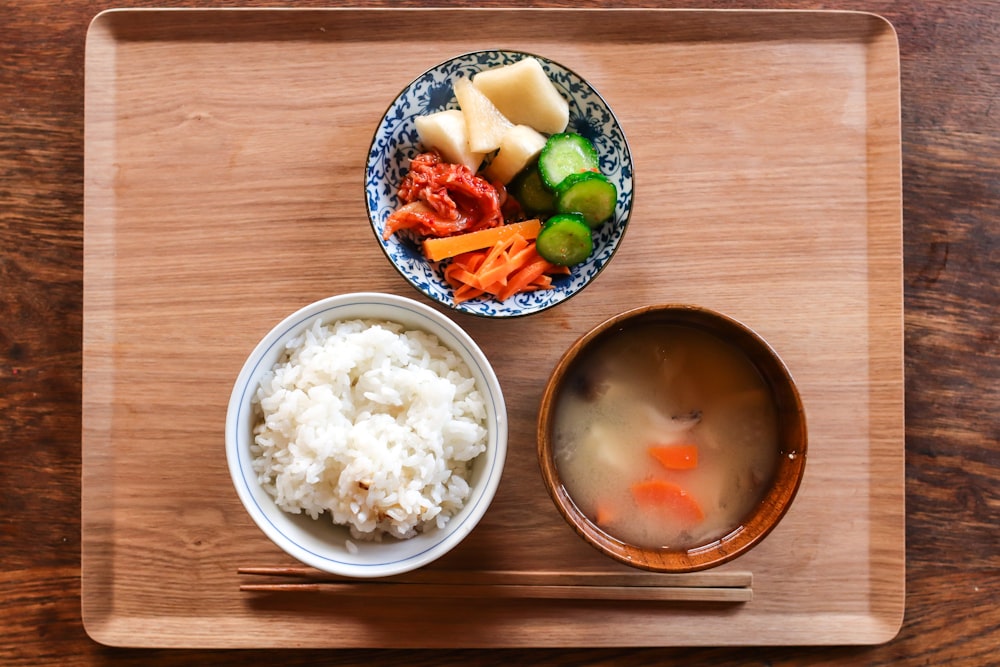 three kinds of foods on bowls on top of brown serving tray