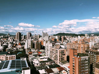 Close-up of hands exchanging carbon credit certificates with a backdrop of a city skyline powered by renewable energy.