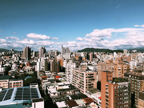 Close-up of hands exchanging carbon credit certificates with a backdrop of a city skyline powered by renewable energy.