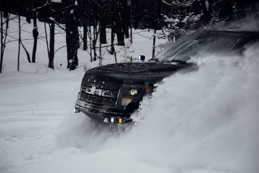 black vehicle passing on snow ground