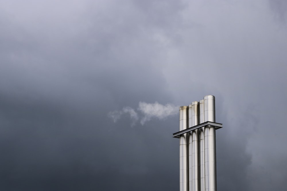 three tubular silver metal under gray sky