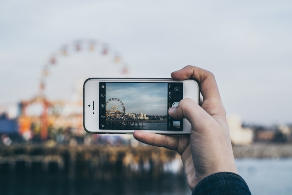 Person, die das Riesenrad fotografiert