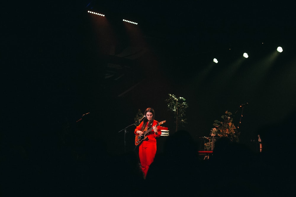 person in red clothes playing guitar