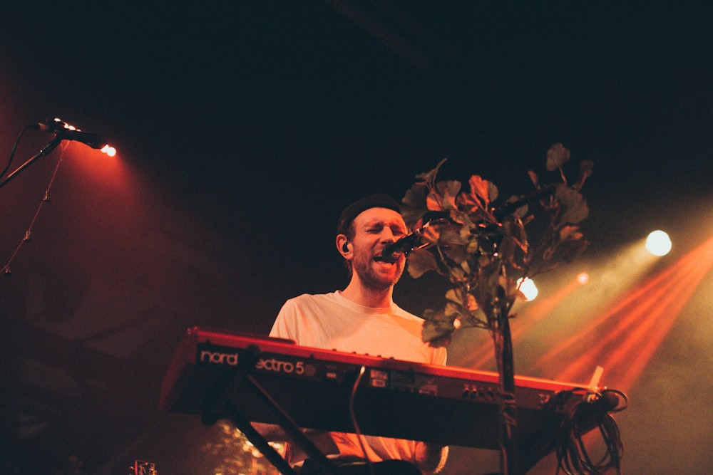 man sings while playing keyboards