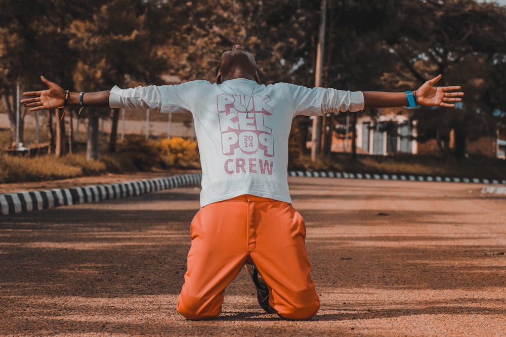 man kneeling in the middle of the road