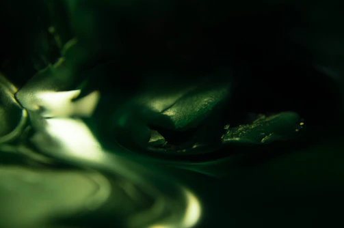 Close-up of a smooth, abstract skincare texture in muted green tones.