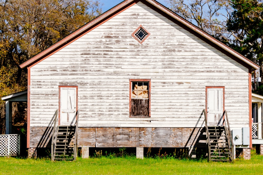 Maison en bois blanc et gris près des arbres