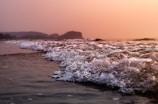Sunset over a Southern California beach with waves gently rolling in.