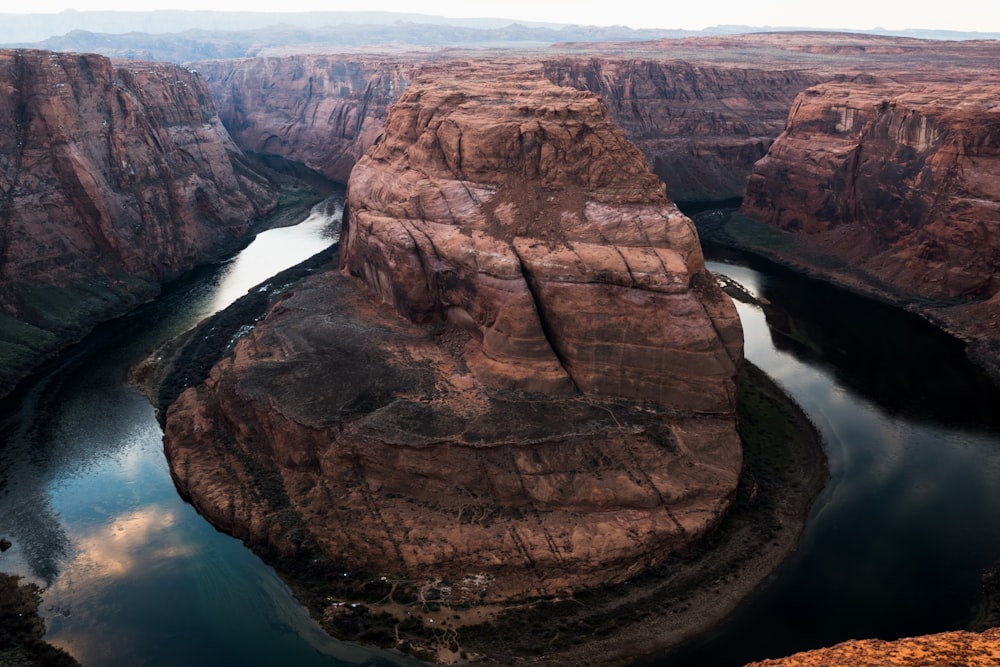 photo of brown buttes surrounded with river