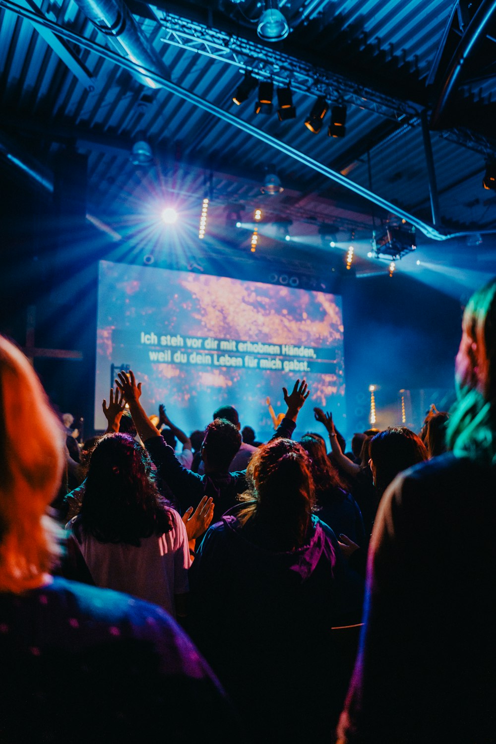 people worshiping and gathering inside gym