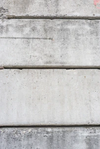 Close-up of a smooth, grey precast concrete slab with sharp edges under bright industrial lighting.