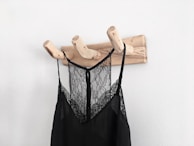 Close-up of a freestanding coat tree showcasing its sturdy metal hooks and raw finish.