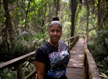 A smiling woman enjoying a peaceful nature walk in a forest