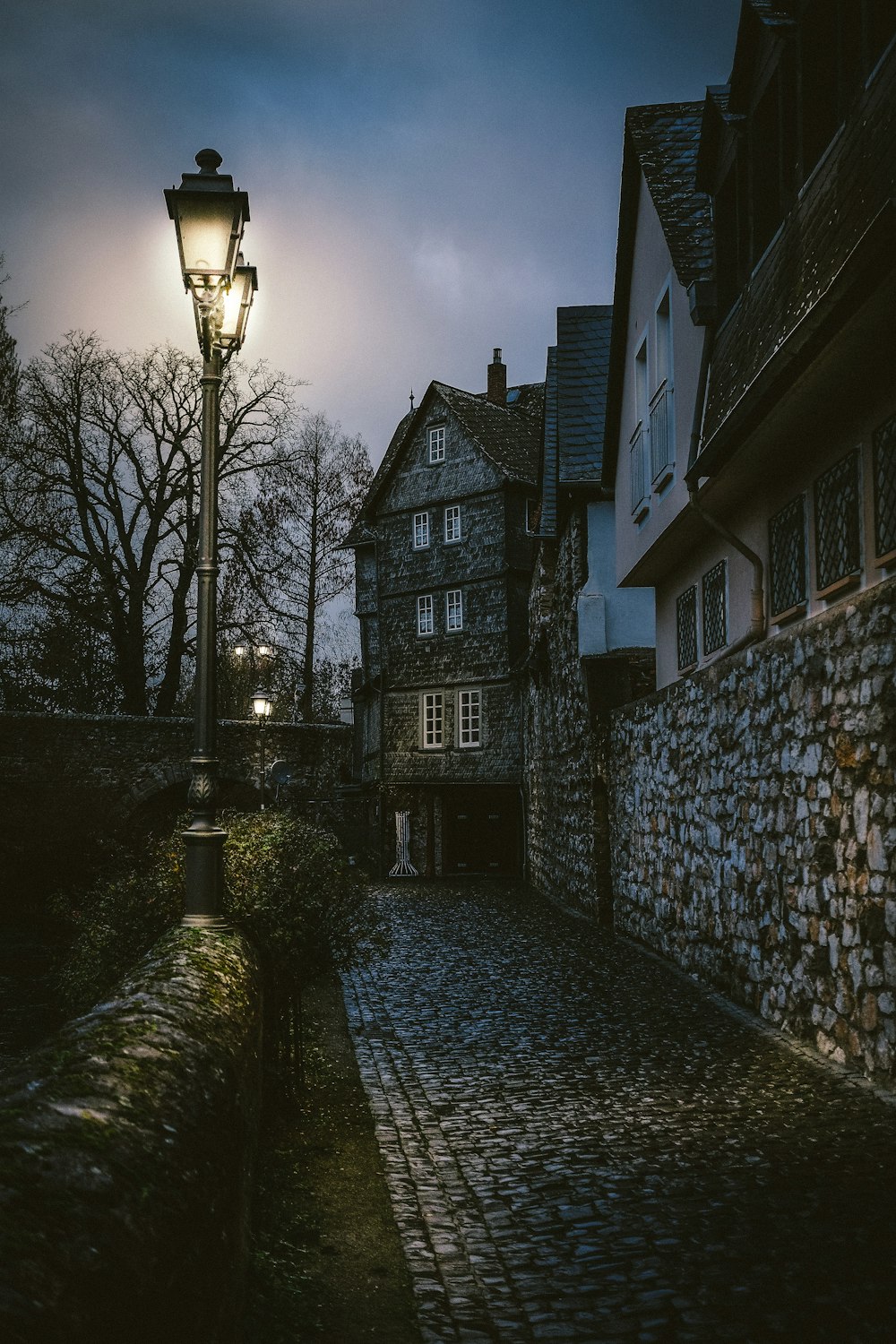 Graue Außenleuchten neben Steinwegenw