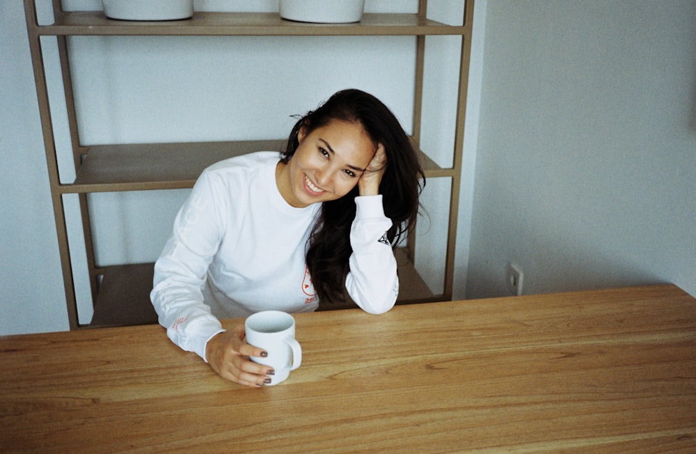 woman sitting on chair holding white mug