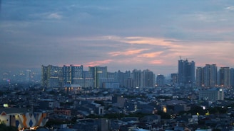 A bustling city skyline at sunset highlighting modern office buildings.