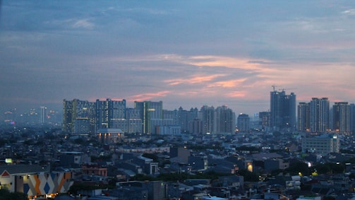 A bustling Indian city skyline with residential buildings at sunset.