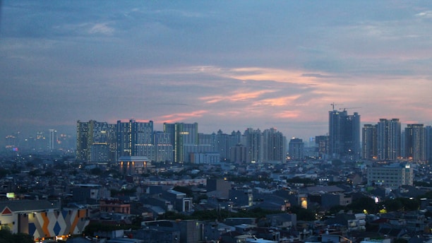 Downtown cityscape with modern apartments and bustling streets at sunset.