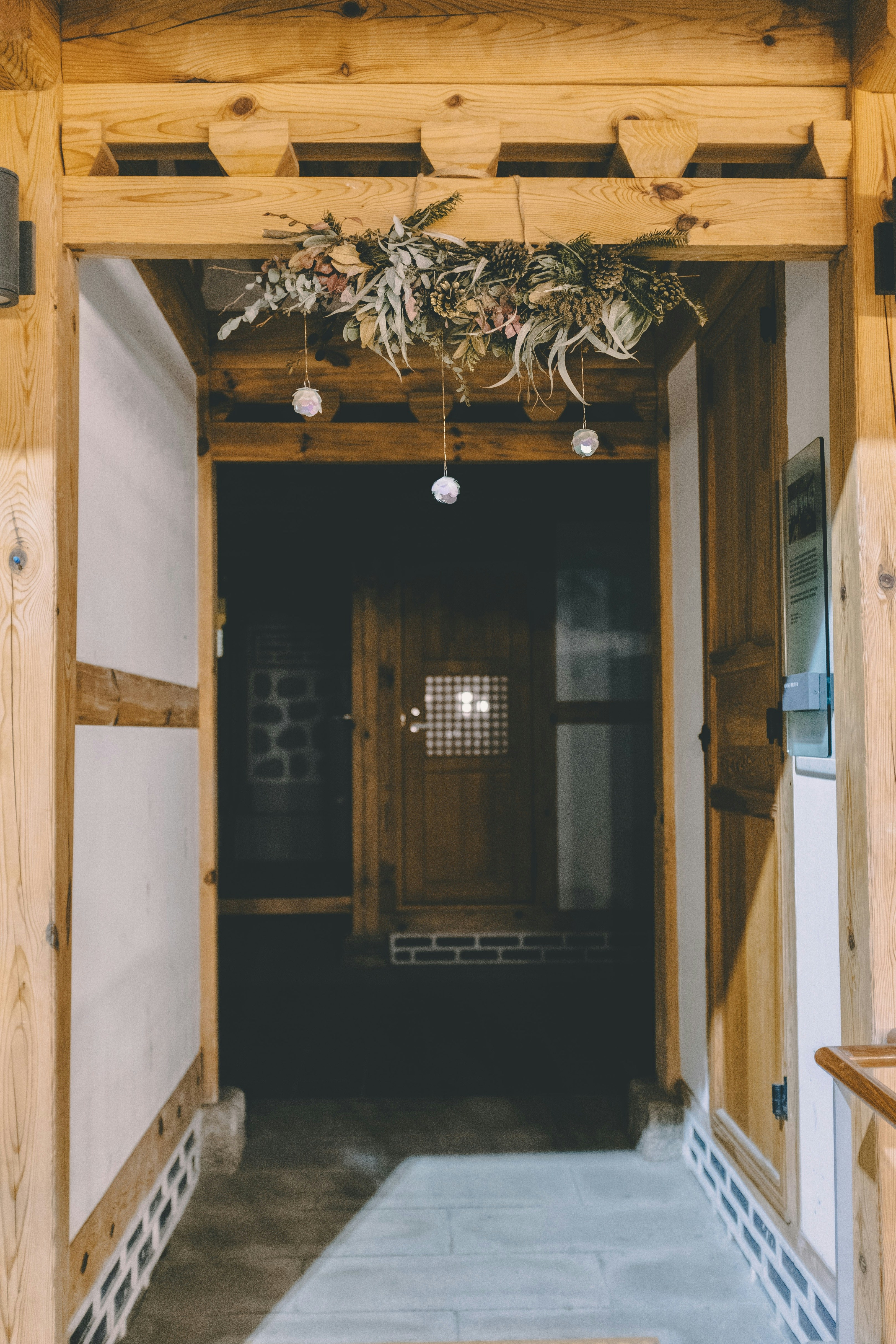 Una corona decorativa de follaje cuelga sobre una entrada de madera tradicional.