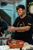 A chef carefully preparing chicken buns in the kitchen.
