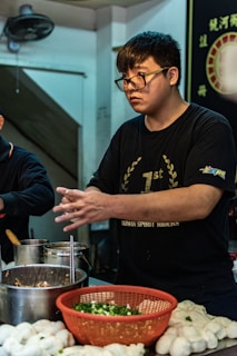 A chef carefully preparing chicken buns in the kitchen.