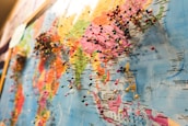 A world map densely populated with colorful pins, each indicating various locations across different continents. The focus is on the regions of Asia and parts of Oceania, with numerous pins clustered together, suggesting popular or significant places.