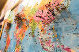 A world map densely populated with colorful pins, each indicating various locations across different continents. The focus is on the regions of Asia and parts of Oceania, with numerous pins clustered together, suggesting popular or significant places.