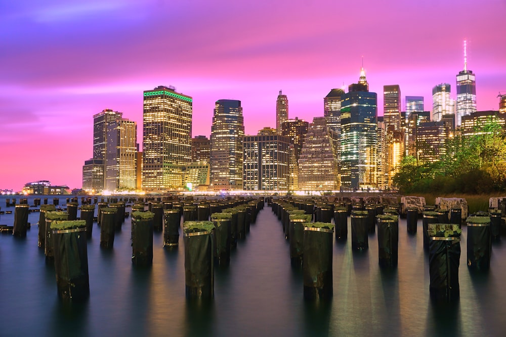 lighted high-rise buildings under purple sky