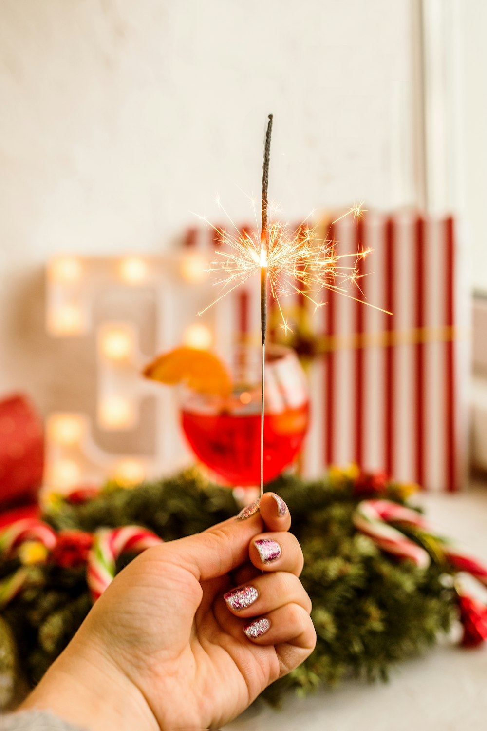 person holding sparkler in selective focus photography