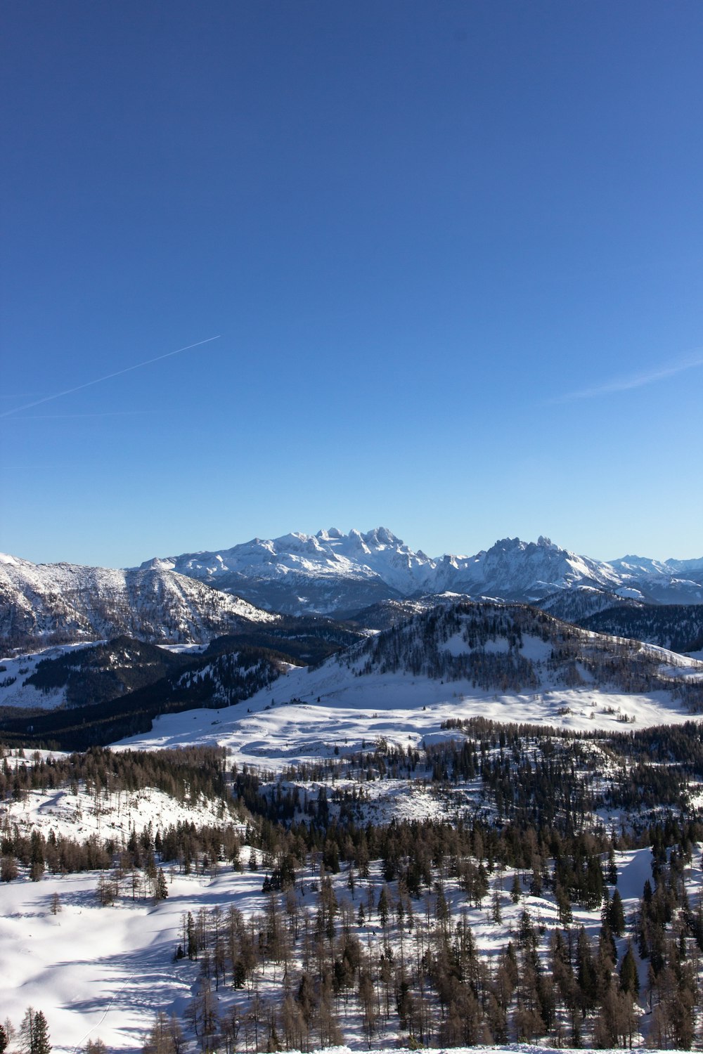 montanha coberta de neve sob o céu azul durante o dia