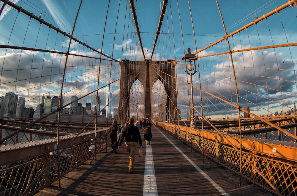 people walking on bridge under blue sky during daytime