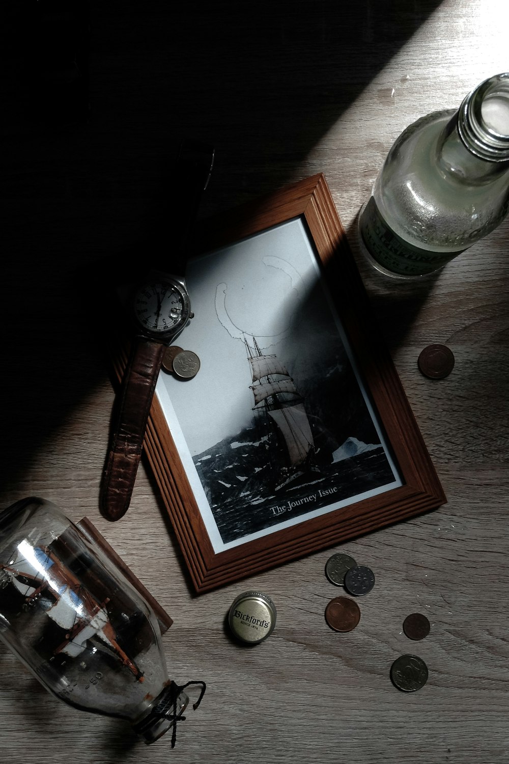 round silver-colored analog watch on brown wooden photo frame