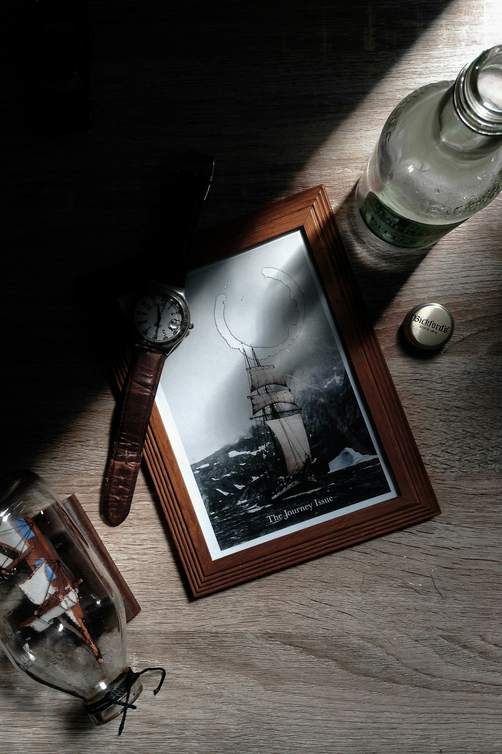 analog watch near photo frame and glass bottle