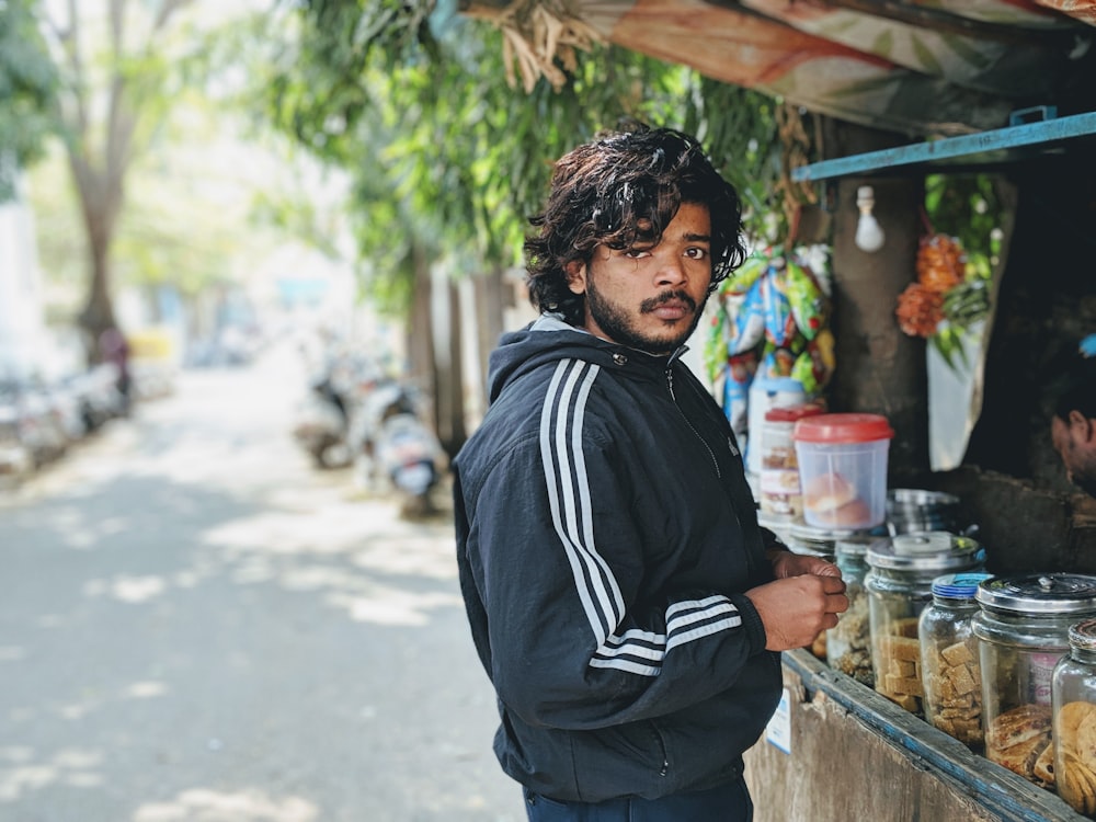 man standing beside food cart