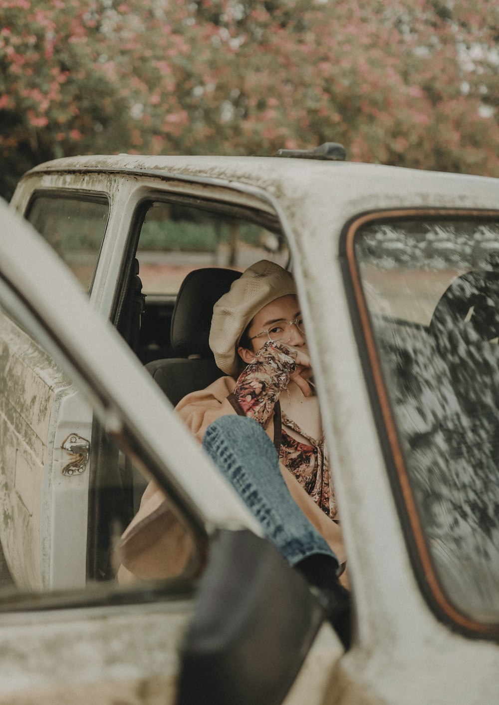 man sits inside parked car with open door