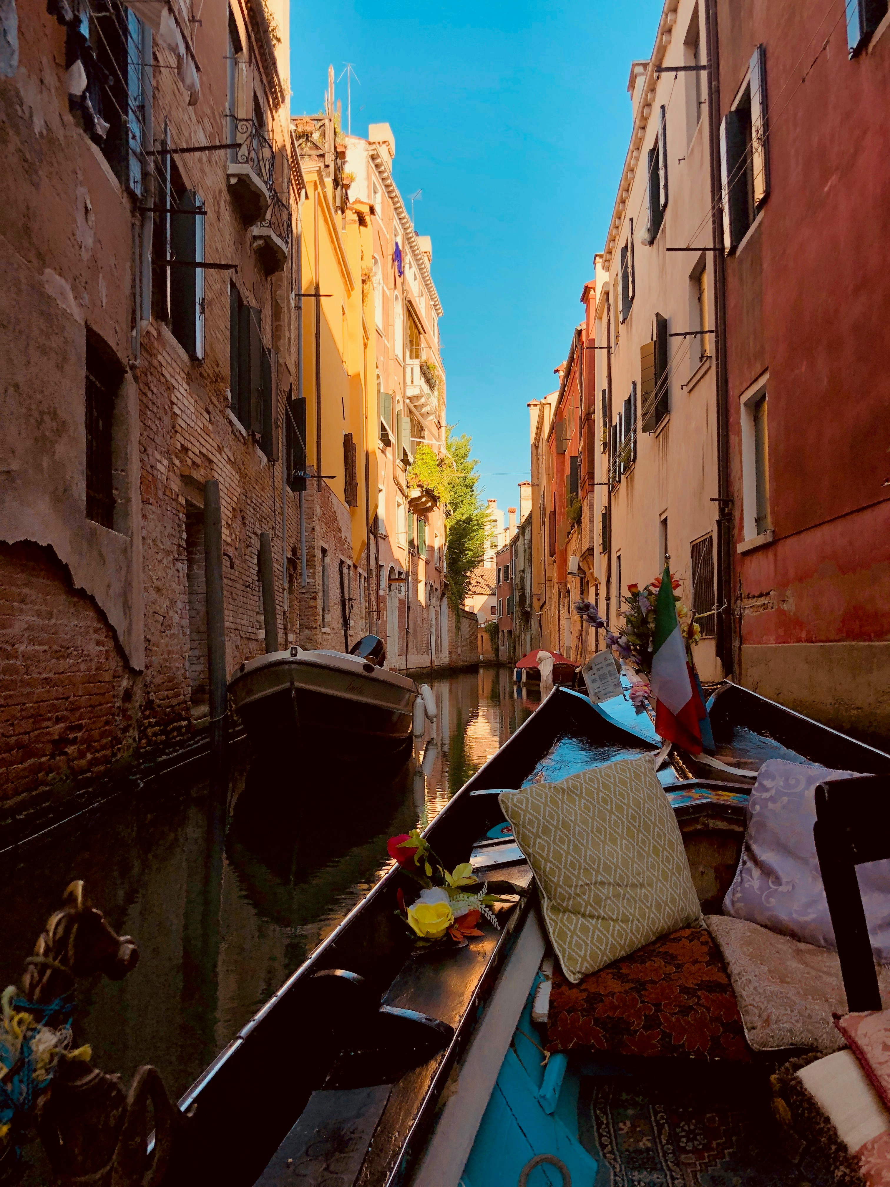 boats in between buildings at daytime