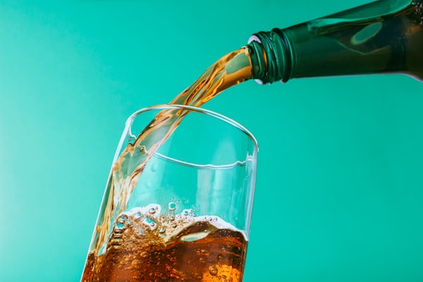 Soda is poured from a bottle into a glass.