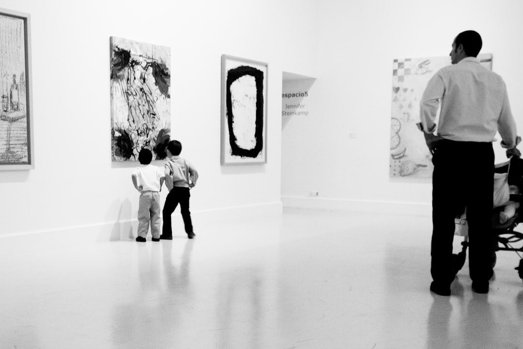 grayscale photography of two boys looking painting