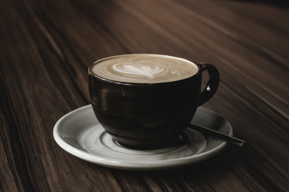 Cappuccino in a ceramic cup on a rich wooden table