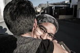 woman hugging man beside street during daytime
