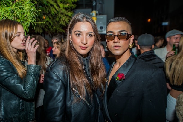 A diverse group of stylish individuals wearing a variety of modern outfits outdoors