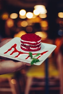 Elegant flat lay of a red velvet dessert with subtle shadows on a black background.