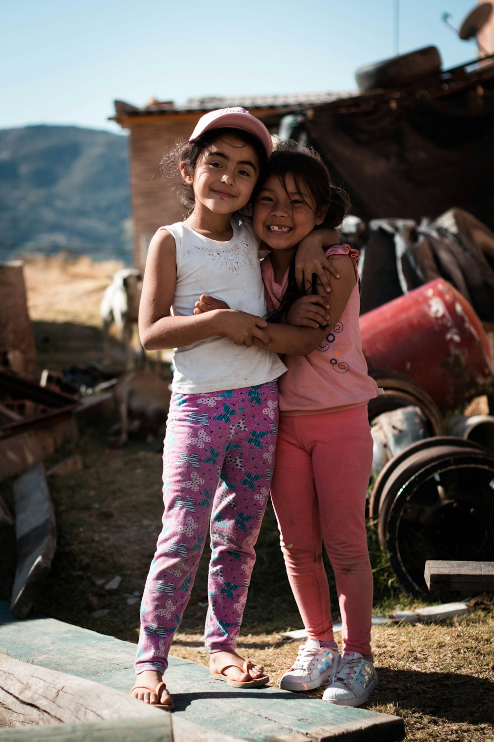 two girls hugging beside metal tool part