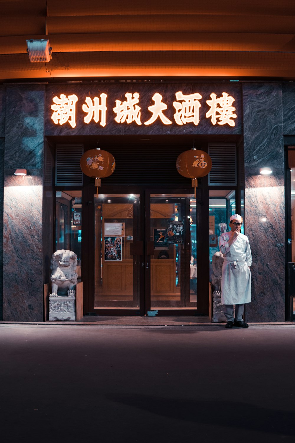 man in white top standing near at door