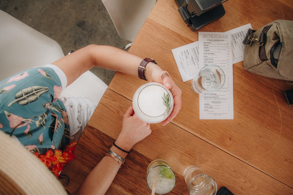 flat-lay photography of person holding drinking glass