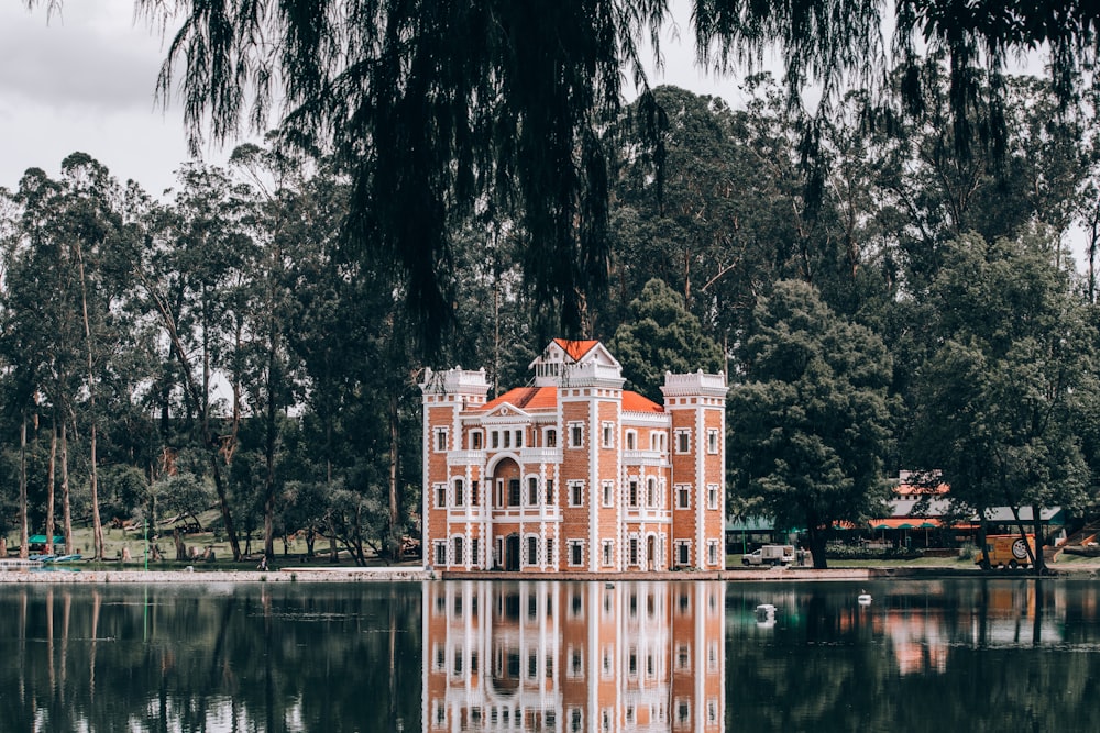 orange and white concrete building beside water
