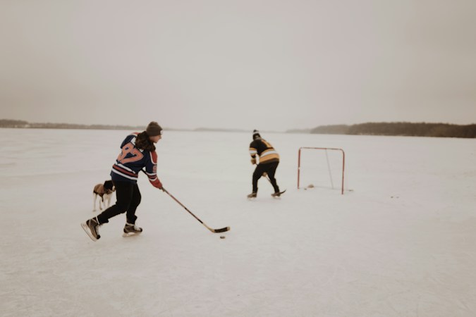 Two players with sticks chase a puck toward a hockey net on an open sheet of ice, a reminder of the rink time young players put in before a debut like Trevor Connelly's