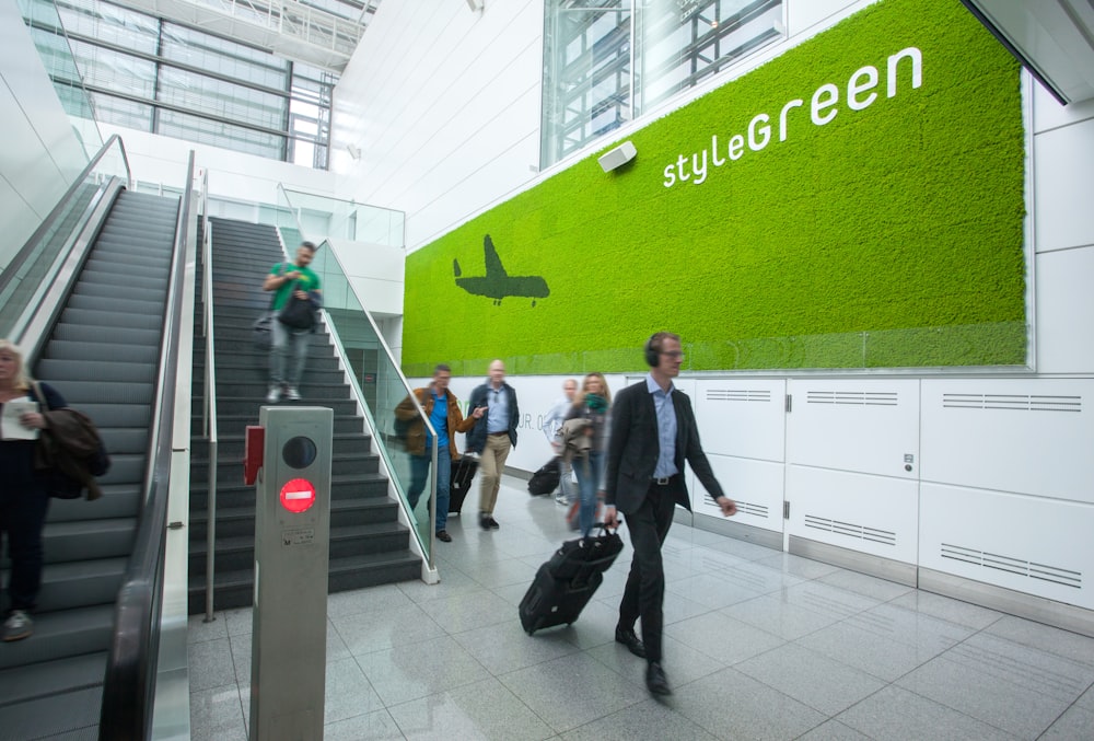 Menschen, die mit Rolltreppe in das Gebäude gehen