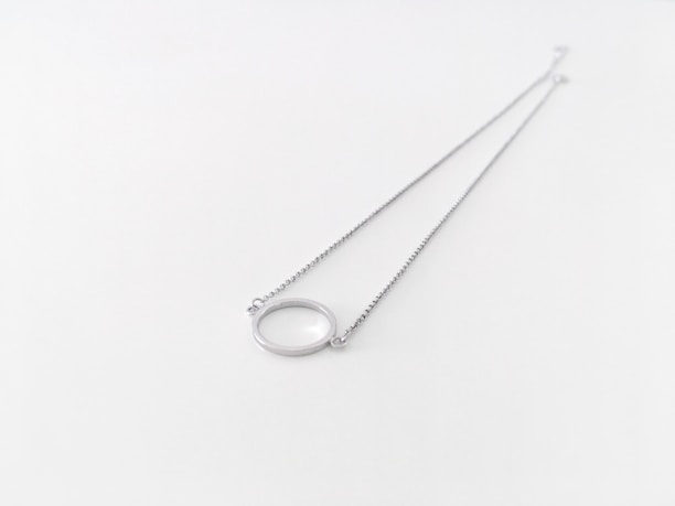 Happy customer wearing a delicate silver necklace with a golden pendant.