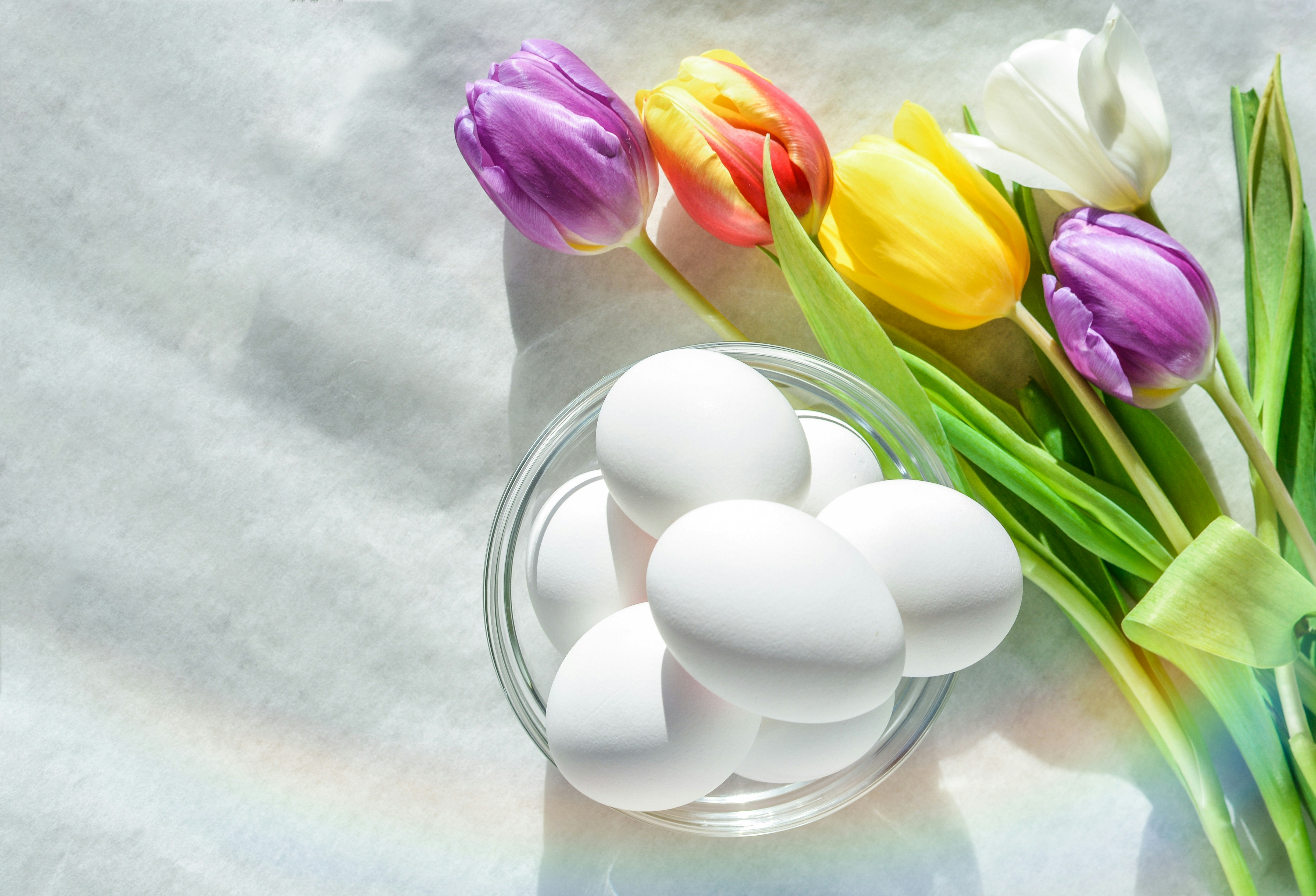 Small round white and green African garden eggs eggplants in a wooden bowl, clean bright background